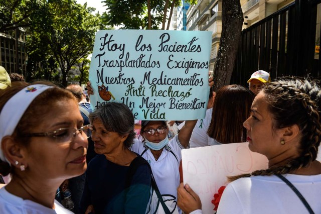 A woman holds a sign during an anti-government demonstration protesting for the shortage of medicines in Caracas on November 20, 2017. / AFP PHOTO / FEDERICO PARRA