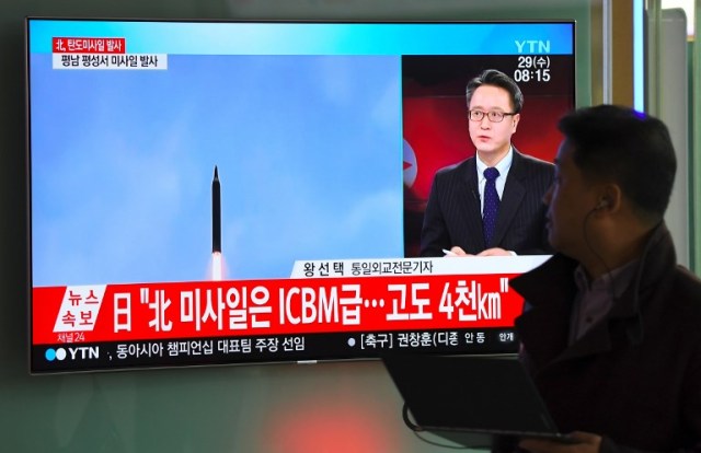 A man walks past a television screen showing a file video footage of North Korea's missile launch, at a railway station in Seoul on November 29, 2017. North Korea test fired what appeared to be an intercontinental ballistic missile on November 29, in a major challenge to US President Donald Trump after he slapped fresh sanctions on Pyongyang and declared it a state sponsor of terrorism. / AFP PHOTO / JUNG Yeon-Je
