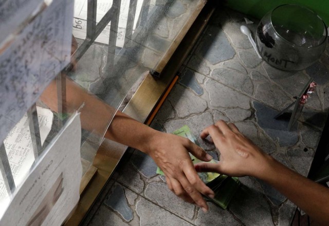 A gambler wagers money on "Los Animalitos" (or the Little Animals) betting game on the outskirts of Caracas, Venezuela, October 9, 2017. REUTERS/Ricardo Moraes SEARCH "MORAES GAMBLING" FOR THIS STORY. SEARCH "WIDER IMAGE" FOR ALL STORIES.