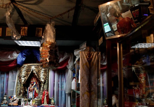 A child is reflected in a mirror as he wagers money on "Los Animalitos" (or the Little Animals) betting game in a grocery shop in Caracas, Venezuela, October 10, 2017. REUTERS/Ricardo Moraes SEARCH "MORAES GAMBLING" FOR THIS STORY. SEARCH "WIDER IMAGE" FOR ALL STORIES.