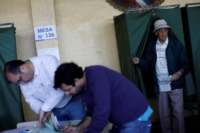 A citizen (R) leaves a booth after voting at a polling station in Santiago, Chile, November 19, 2017. REUTERS/Carlos Garcia Rawlins