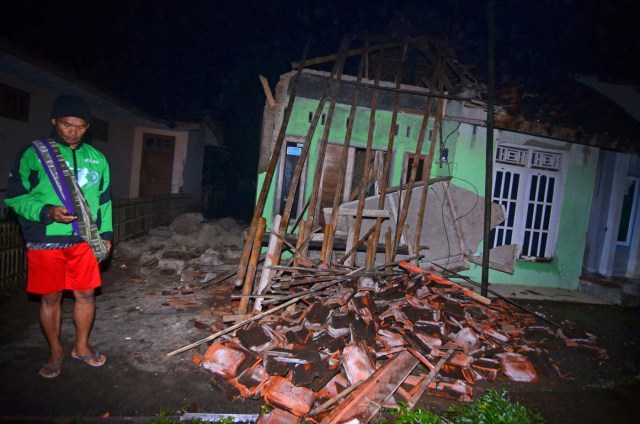 A villager stands near a damaged house after an earthquake hit Sumelap village in Tasikmalaya, Indonesia, December 16, 2017, in this photo taken by Antara Foto. Antara Foto/Adeng Bustomi/ via REUTERS ATTENTION EDITORS - THIS IMAGE WAS PROVIDED BY A THIRD PARTY. MANDATORY CREDIT. INDONESIA OUT.