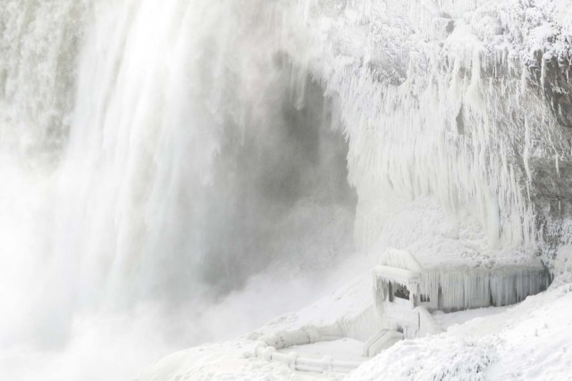 Ice coats the rocks and observation deck at the base of the Horseshoe falls in Niagara Falls, Ontario on January 3, 2018. The cold snap which has gripped much of Canada and the United States has nearly frozen over the American side of the falls. / AFP PHOTO / Geoff Robins