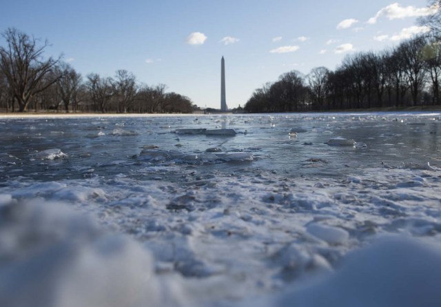 The Washington Monument is seen across the frozen reflecting pool in Washington, DC on January 5, 2018. The National Weather Service said that very cold temperatures and wind chills will follow for much of the eastern third of the US through the weekend. A cold wave gripping a large section of the United States had already been blamed for a dozen deaths. / AFP PHOTO / Andrew CABALLERO-REYNOLDS