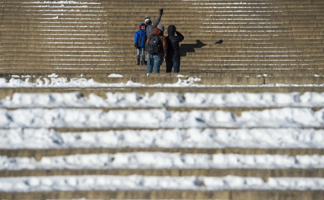 Tourists have photos taken on the steps of the Lincoln memorial in Washington, DC on January 5, 2018. The National Weather Service said that very cold temperatures and wind chills will follow for much of the eastern third of the US through the weekend. A cold wave gripping a large section of the United States had already been blamed for a dozen deaths. / AFP PHOTO / ANDREW CABALLERO-REYNOLDS