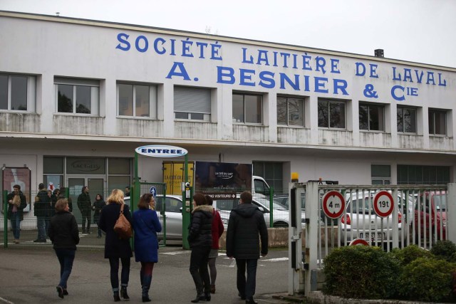 Employees walk in front of the entrance of the French dairy group Lactalis headquarters in Laval, western France, January 12, 2018. REUTERS/Stephane Mahe