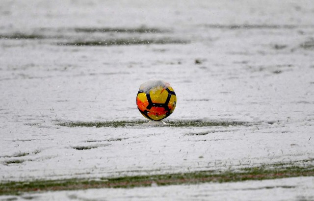 This photo taken on February 25, 2018 shows snow covering a ball and the pitch prior to the postponement of the Italian Serie A football match Juventus versus Atalanta at the Allianz Stadium in Turin.  The Italian Serie A football match Juventus versus Atalanta on February 25 has been postponed due to weather.  / AFP PHOTO / ALBERTO PIZZOLI