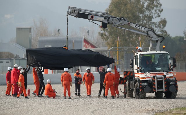 F1 Formula One - Formula One Test Session - Circuit de Barcelona Catalunya, Montmelo, Spain - February 26, 2018 The car belonging to Fernando Alonso of McLaren is lifted away after a tyre fell off during testing REUTERS/Albert Gea