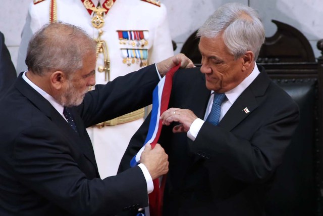 Chile's new President Sebastian Pinera (R) receives the presidential sash from Senate President Carlos Montes during his inauguration ceremony at the Congress in Valparaiso, Chile, on March 11, 2018. Rightwing billionaire businessman Pinera was sworn in as the new president of Chile for the second time. / AFP PHOTO / CLAUDIO REYES