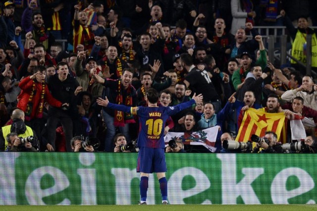 Barcelona's Argentinian forward Lionel Messi celebrates with supporters after scoring his team's third goal during the UEFA Champions League round of sixteen second leg football match between FC Barcelona and Chelsea FC at the Camp Nou stadium in Barcelona on March 14, 2018. / AFP PHOTO / Josep LAGO