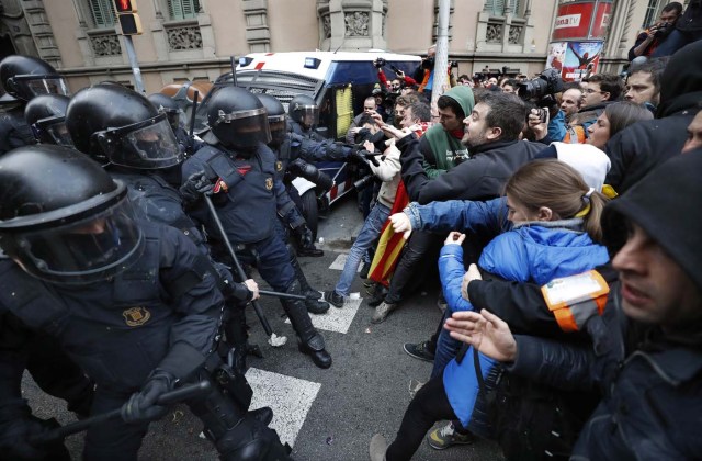 GRAF407. BARCELONA, 25/3/2018.- Miembros de los Mossos d´Esquadra impiden el paso de manifestantes en las inmediaciones de la Delegación del Gobierno en Cataluña, donde centenares de independentistas tratan de desbordar el cordón policial en protesta por la detención del expresidente catalán Carles Puigdemont. . EFE/ Andreu Dalmau.