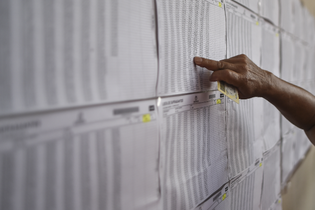 Un hombre revisa el censo electoral en una mesa electoral en Cali, departamento del Valle del Cauca, durante las elecciones parlamentarias en Colombia el 11 de marzo de 2018. Luis ROBAYO / AFP