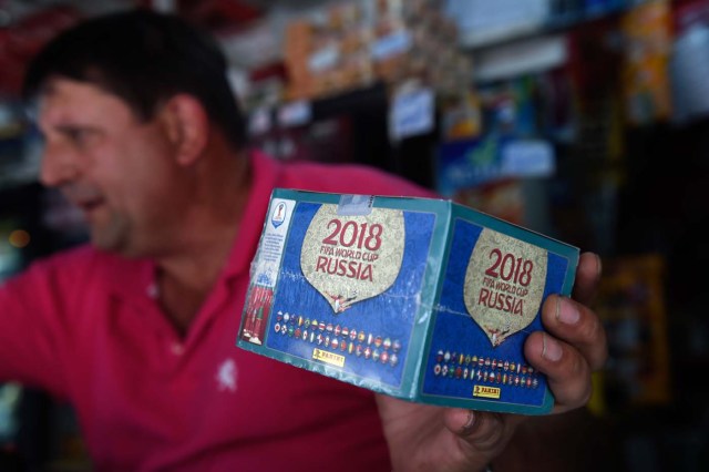 A newsstand vendor shows a box of collectible trading cards of the album Russia 2018 in Caracas on April 2, 2018. Due to the economic crisis in Venezuela, fans are not able to collect the FIFA World Cup Russia 2018 picture cards. / AFP PHOTO / FEDERICO PARRA / TO GO WITH AFP STORY BY ALEXANDER MARTINEZ