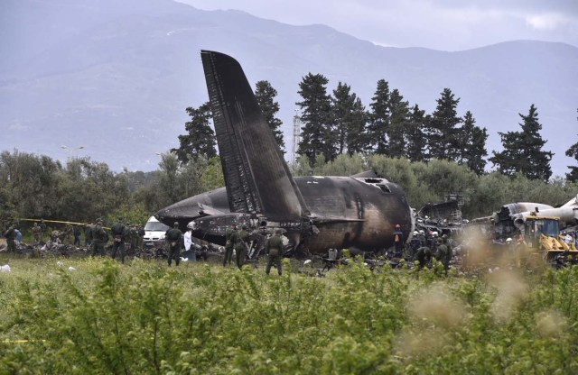 Rescuers are seen around the wreckage of an Algerian army plane which crashed near the Boufarik airbase from where the plane had taken off on April 11, 2018. The Algerian military plane crashed and caught fire killing 257 people, mostly army personnel and members of their families, officials said. / AFP PHOTO / Ryad KRAMDI