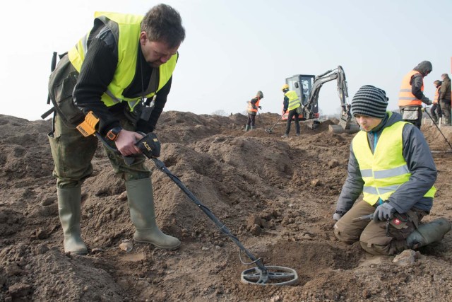 Amateur archaeologist Rene Schoen (L) and 13-year-old student Luca Malaschnichenko look for a treasure with a metal detector in Schaprode, northern Germany on April 13, 2018. The 13-year-old boy and the hobby archaeologist have unearthed a "significant" trove in Germany which may have belonged to the legendary Danish king Harald Bluetooth who brought Christianity to Denmark. A dig covering 400 square metres (4,300 square feet) that finally started over the weekend by the regional archaeology service has since uncovered a trove believed linked to the Danish king who reigned from around 958 to 986. Braided necklaces, pearls, brooches, a Thor's hammer, rings and up to 600 chipped coins were found, including more than 100 that date back to Bluetooth's era. / AFP PHOTO / dpa / Stefan Sauer / Germany OUT