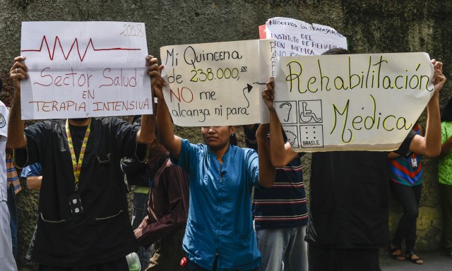 Health workers and patients protest for the lack of medicines, medical supplies and poor conditions in hospitals, in Caracas on April 17, 2018. Doctors and nurses protest against the health crisis in Venezuela, currently in the midst of a deep economic and political crisis and where health authorities have reported a rise in vaccine-preventable diseases. / AFP PHOTO / Luis ROBAYO