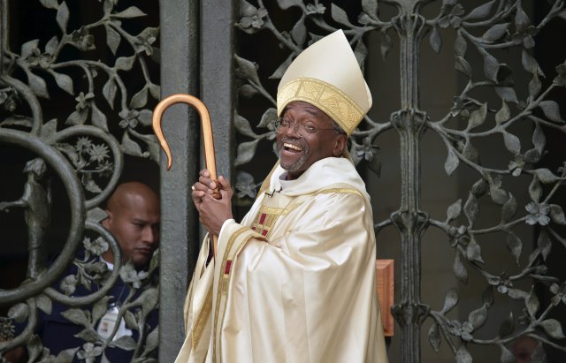 FILE PHOTO: The Reverend Michael Bruce Curry laughs as he waits for the traditional opening of the doors after arriving for his Installation ceremony at the Washington National Cathedral, in Washington, November 1, 2015. Curry becomes the first African-American Episcopal presiding bishop, after previoulsy serving as Bishop of North Carolina.               REUTERS/Mike Theiler/File Photo