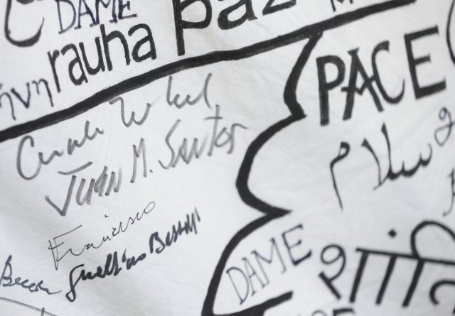 Los autógrafos de la canciller alemana Angela Merkel y del presidente colombiano Juan Manuel Santos se ven cerca de un letrero del Papa Francisco en una bandera de la paz después de su visita a Asís, Italia, el 12 de mayo de 2018. REUTERS / Yara Nardi 