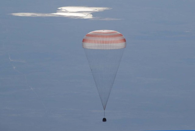 La cápsula Soyuz MS-07 con la tripulación del Norishige Kanai de Japón, Anton Shkaplerov de Rusia y Scott Tingle de EE. UU. Desciende debajo de un paracaídas justo antes de aterrizar en un área remota a las afueras de la ciudad de Dzhezkazgan (Zhezkazgan), Kazajistán 3 de junio. 2018. Dmitri Lovetsky / Pool a través de REUTERS