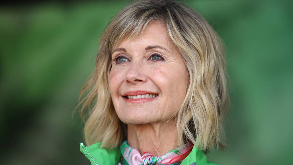 La actriz Olivia Newton John condecorada por la reina Isabel II