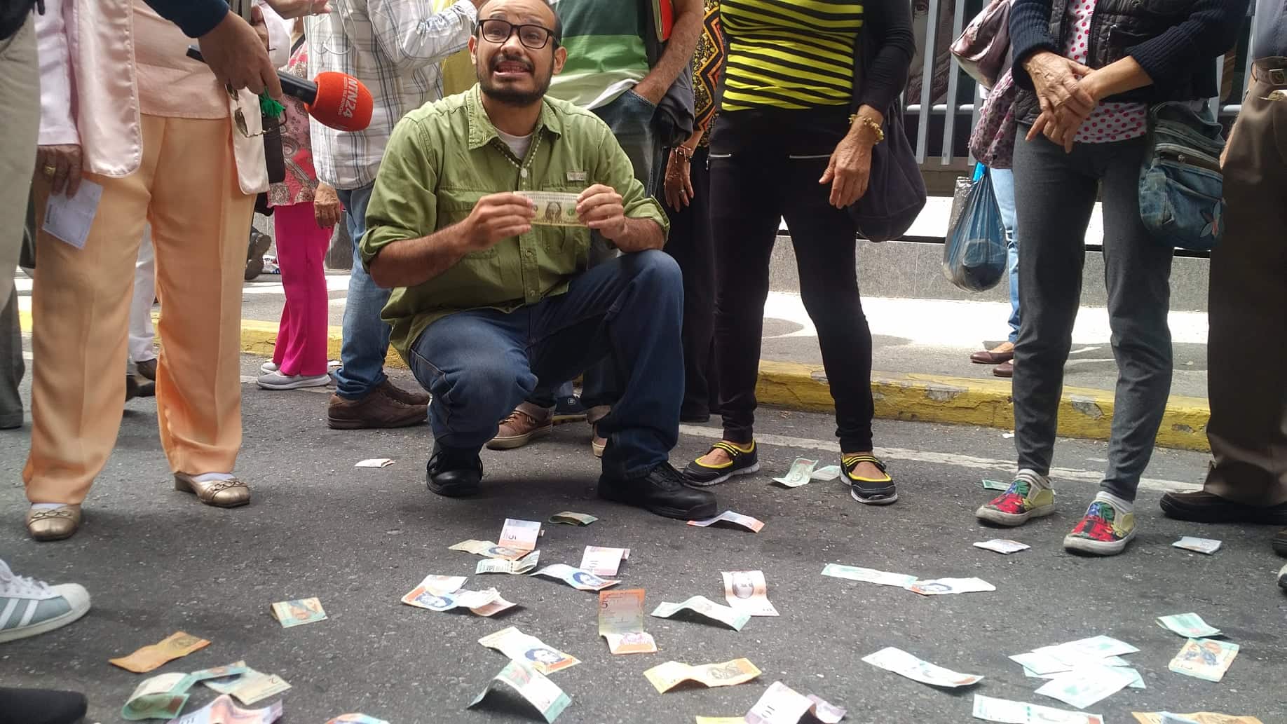 Vecinos y jubilados lanzan billetes en las puertas del BCV y dicen que el Bolívar no vale nada